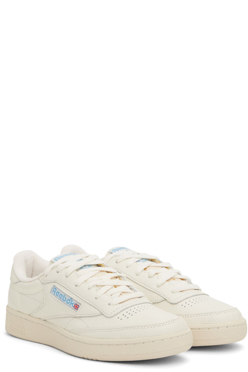 Low-top buffed leather sneakers in off-white.

· Perforated detailing at vamp
· Lace-up closure
· Logo patch at padded tongue
· Padded collar
· Inset logo patch at outer side
· Logo printed at heel tab
· Terry cloth lining
· Foam rubber midsole
· Treaded rubber sole

Supplier color: Chalk/Alabaster/Essential blue