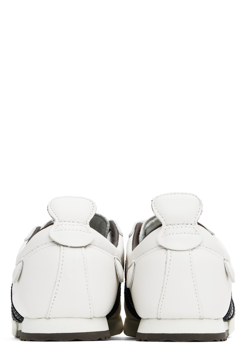 Low-top buffed leather sneakers in off-white.

· Suede trim at toe
· Lace-up closure
· Padded collar
· Signature serrated stripes at sides
· Pull-tab at sides and heel collar
· Logo stamp at outer side
· Grained leather lining
· Foam rubber midsole
· Treaded rubber sole

Supplier color: Cloud white/Core black/Brown