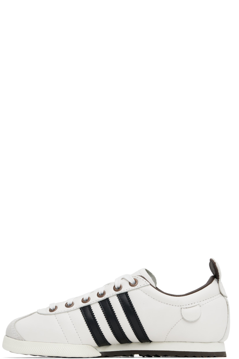 Low-top buffed leather sneakers in off-white.

· Suede trim at toe
· Lace-up closure
· Padded collar
· Signature serrated stripes at sides
· Pull-tab at sides and heel collar
· Logo stamp at outer side
· Grained leather lining
· Foam rubber midsole
· Treaded rubber sole

Supplier color: Cloud white/Core black/Brown