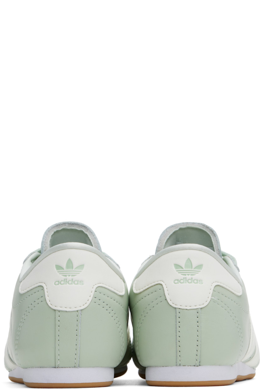 Low-top grained leather sneakers in green.

· Quilting at toe
· Lace-up closure
· Logo printed at padded tongue
· Padded collar
· Perforations and signature stripes at sides
· Logo embossed at heel tab
· Jersey lining
· Treaded rubber sole

Supplier color: Linen green/Off white/Cloud white