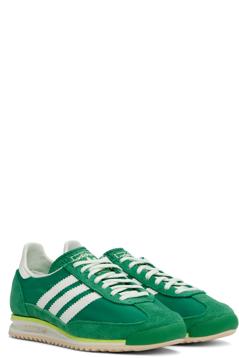 Low-top canvas and suede sneakers in green.

· Lace-up closure
· Logo printed at textured tongue
· Padded heel collar
· Signature serrated stripes at sides
· Logo embossed at buffed leather heel tab
· Buffed faux-leather and mesh lining
· Logo embossed at foam rubber midsole
· Treaded rubber sole

Supplier color: Court green/Ivory/Crystal sand