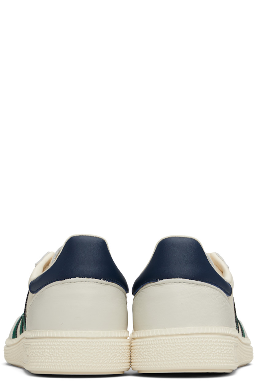 Low-top grained leather sneakers.

· Lace-up closure
· Logo patch at tongue
· Padded collar
· Signature serrated stripes at sides
· Text stamped at outer side
· Mesh lining
· Logo embossed at textured rubber midsole
· Treaded rubber sole

Supplier color: Chalk white/Collegiate green/Night indigo