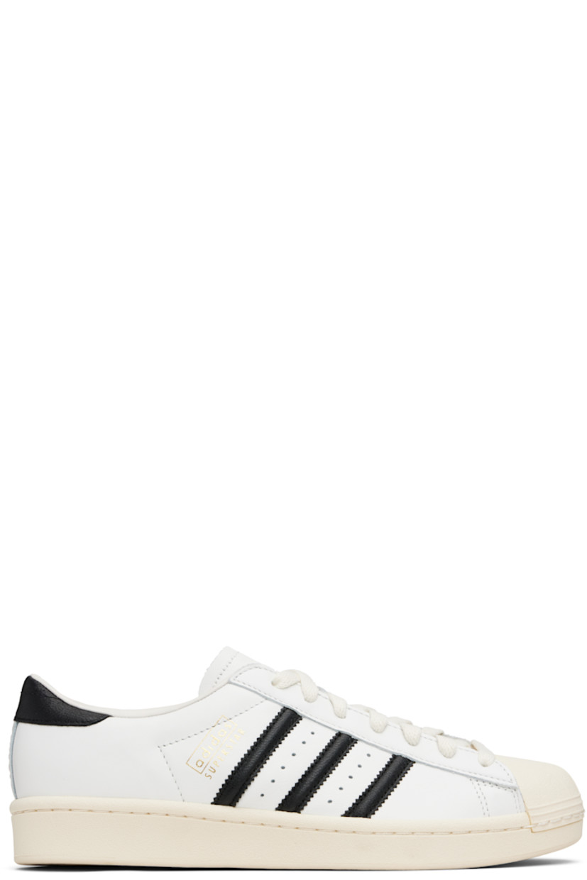 Low-top buffed leather sneakers.

· Textured rubber cap toe
· Lace-up closure
· Padded collar
· Signature serrated stripes and perforations at sides
· Logo stamp at outer side
· Text embossed at heel
· Buffed leather lining
· Treaded rubber sole

Supplier color: Core white/Core black/Cream white