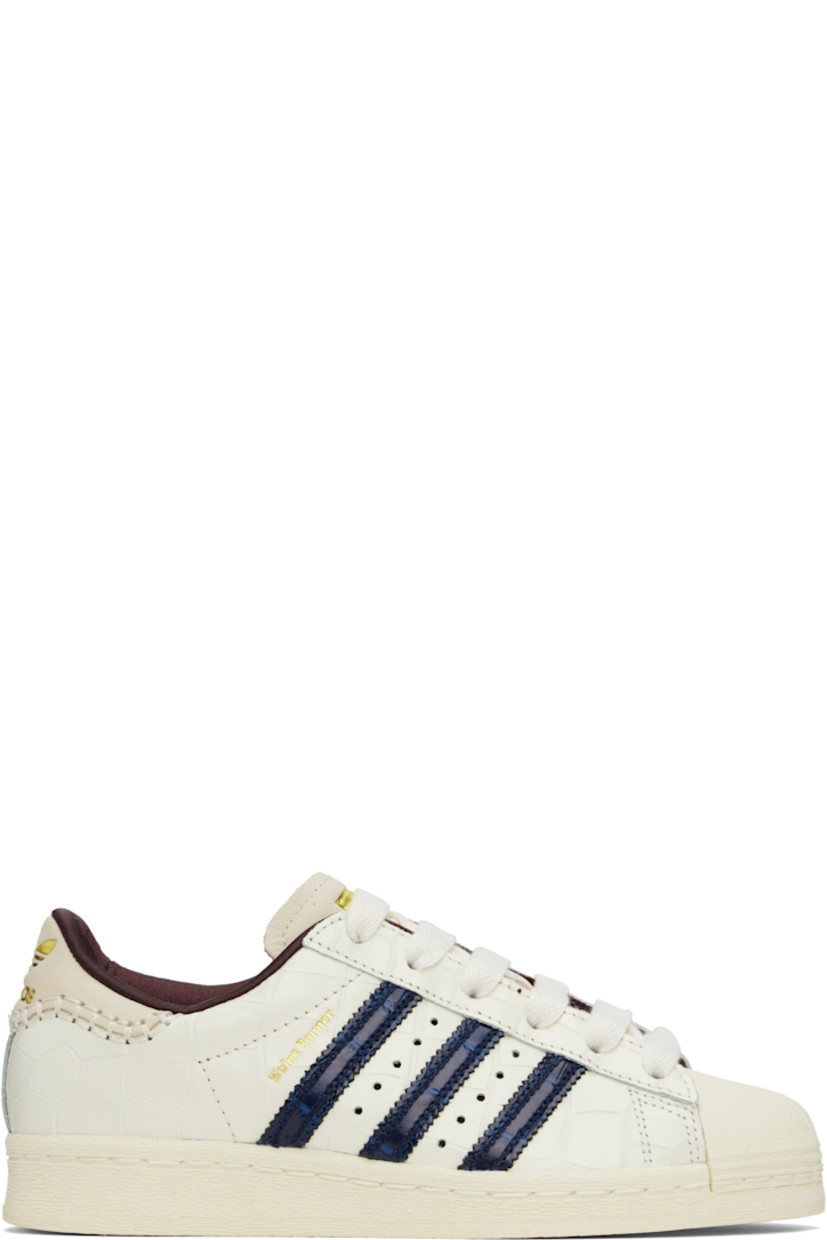 Low-top croc-embossed leather sneakers in white. 

· Textured rubber cap toe
· Lace-up closure
· Logo embossed at padded suede tongue
· Padded collar
· Serrated signature stripes and perforations at sides
· Logo stamp at outer side
· Blanket stitching and logo embossed at suede heel tab
· Satin lining
· Treaded rubber sole

Part of the Wales Bonner x adidas Originals collaboration.

Supplier color: Wonder white/Collegiate navy/Night red