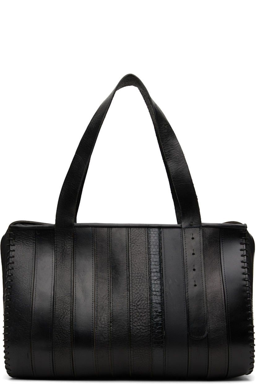 Upcycled leather shoulder bag.

· Paneled construction
· Fixed shoulder straps
· Zip closure
· Twill lining
· Patch pocket at interior
· H9" x W14" x D7"

Each item is constructed using upcycled garments. Please note colorway may vary.