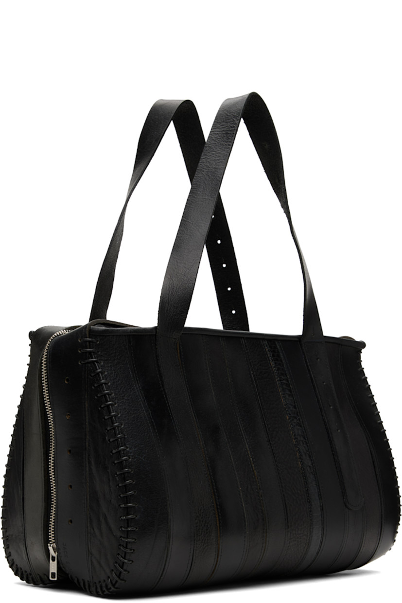 Upcycled leather shoulder bag.

· Paneled construction
· Fixed shoulder straps
· Zip closure
· Twill lining
· Patch pocket at interior
· H9" x W14" x D7"

Each item is constructed using upcycled garments. Please note colorway may vary.