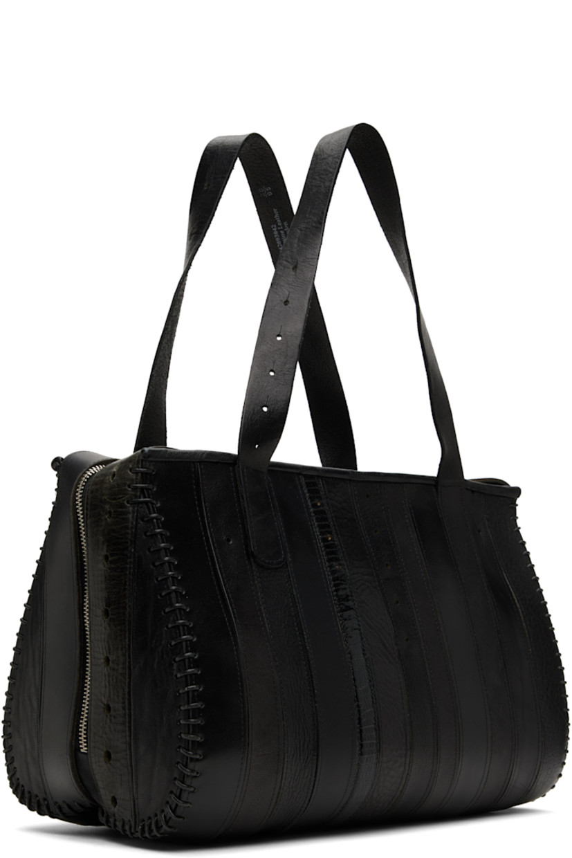 Upcycled leather shoulder bag.

· Paneled construction
· Fixed shoulder straps
· Zip closure
· Twill lining
· Patch pocket at interior
· H9" x W14" x D7"

Each item is constructed using upcycled garments. Please note colorway may vary.