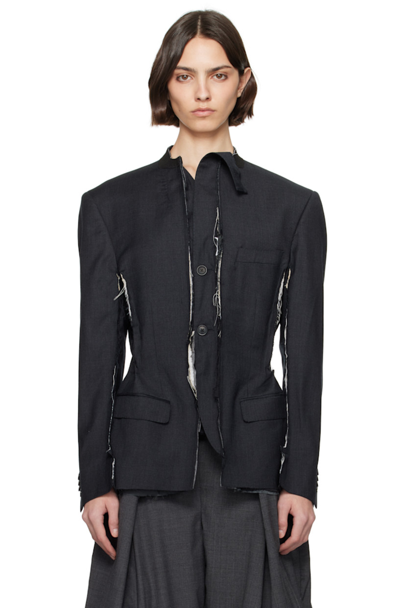 Stretch wool-blend twill blazer. Raw edges and loose thread detailing throughout.

· Felted trim at band collar
· Button closure
· Welt pocket at chest
· Flap pockets
· Pinched seams at side seams, sleeves, and back
· Padded shoulders
· Four-button surgeon's cuffs
· Vents at back hem
· Welt pockets at interior
· Full satin lining

Each item is constructed using upcycled garments. Please note colorways may vary.