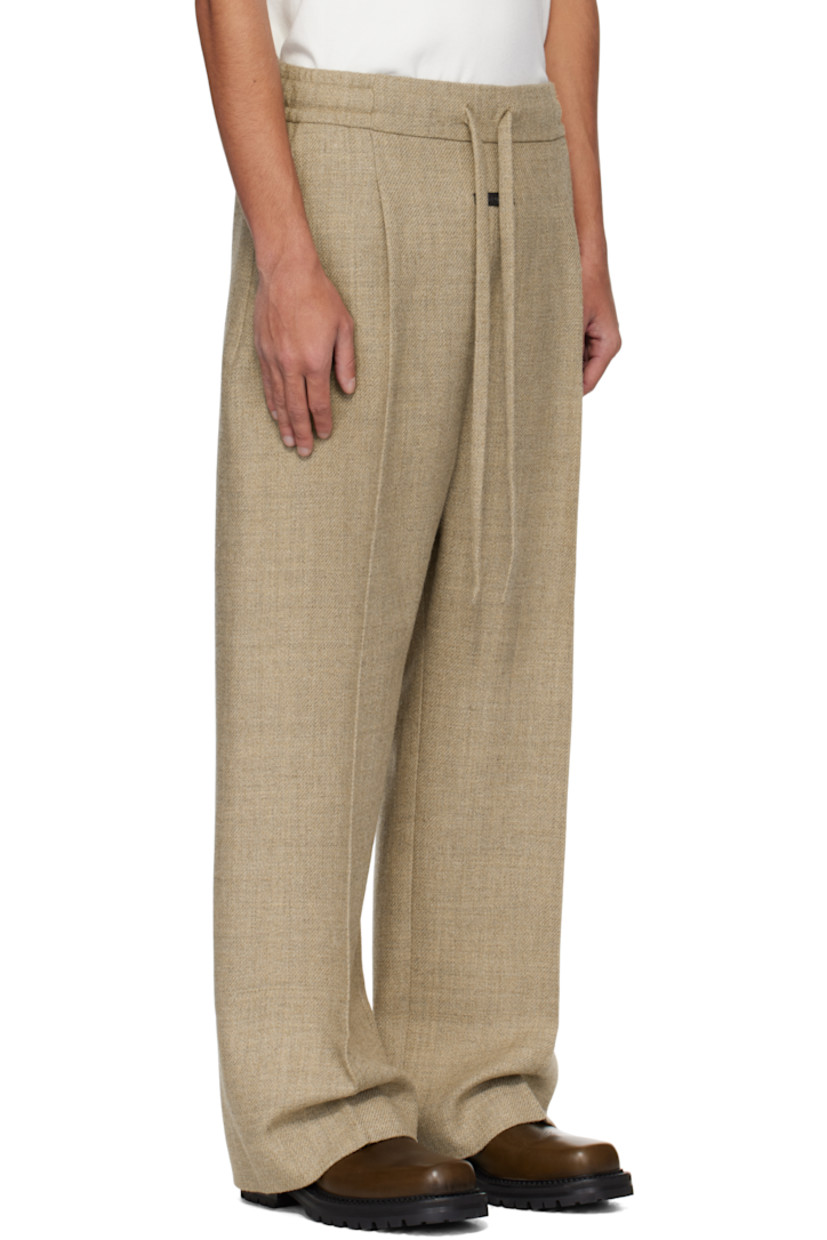 Heavyweight virgin wool-blend twill trousers. 

· Wide-leg
· Drawstring at elasticized waistband 
· Two-pocket styling 
· Pleats and rubberized logo patch at front 
· Creased legs 
· Full satin lining 

Supplier color: Melange beige