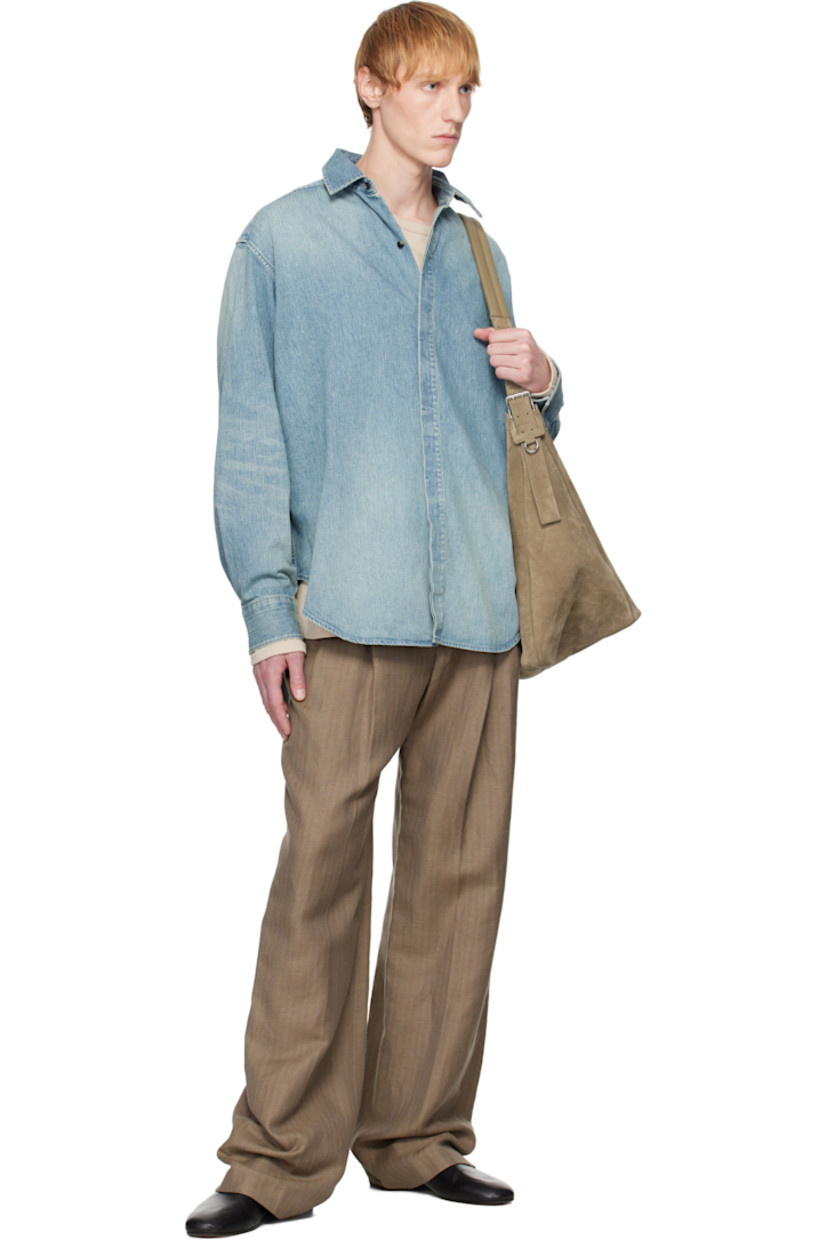 Non-stretch denim shirt. Fading throughout. 

· Spread collar
· Concealed button closure
· Shirttail hem 
· Buttoned barrel cuffs
· Rubberized logo patch at back collar 
· Twin pleats at back yoke
· Horn hardware

Supplier color: Medium indigo