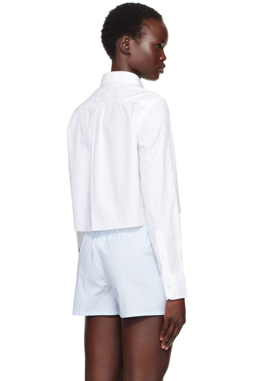 Cotton twill shirt.

· Spread collar
· Button closure
· Logo embroidered at front
· Raw edge at cropped hem
· Pleat at adjustable single-button barrel cuffs
· Box pleat at back yoke

Supplier color: White