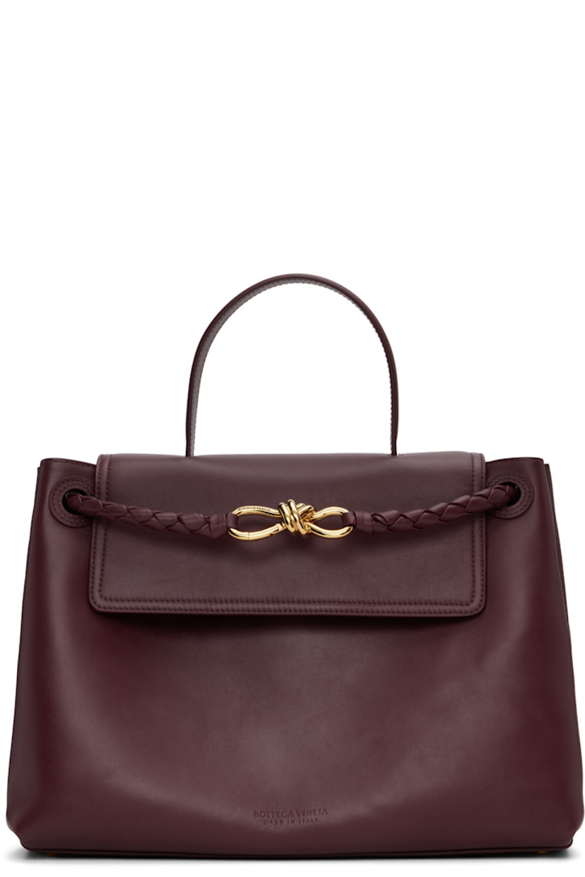 Buffed calfskin top handle bag.

· Fixed carry handle
· Adjustable and detachable shoulder strap
· Sliding intrecciato-woven shoulder straps
· Graphic hardware at strap
· Bumper studs at base
· Hook-eye flap
· Zip pocket at interior
· Suede lining
· H10" x W14" x D6"

Supplier color: Barolo