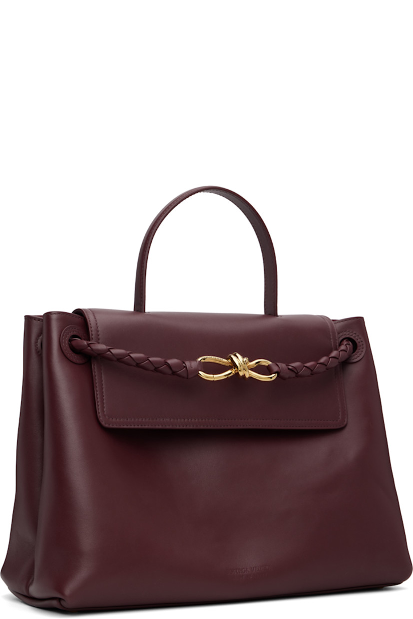 Buffed calfskin top handle bag.

· Fixed carry handle
· Adjustable and detachable shoulder strap
· Sliding intrecciato-woven shoulder straps
· Graphic hardware at strap
· Bumper studs at base
· Hook-eye flap
· Zip pocket at interior
· Suede lining
· H10" x W14" x D6"

Supplier color: Barolo