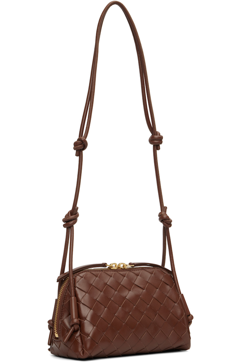 Intrecciato-woven grained calfskin shoulder bag.

· Knots at adjustable shoulder strap
· Two-way zip closure
· Patch pocket at interior
· Buffed leather lining
· Gold-tone hardware
· H4.5" x W7.5" x D3.5"

Supplier color: Sapele