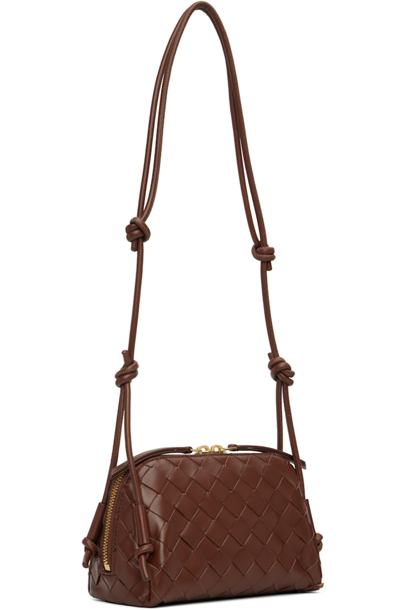 Intrecciato-woven grained calfskin shoulder bag.

· Knots at adjustable shoulder strap
· Two-way zip closure
· Patch pocket at interior
· Buffed leather lining
· Gold-tone hardware
· H4.5" x W7.5" x D3.5"

Supplier color: Sapele