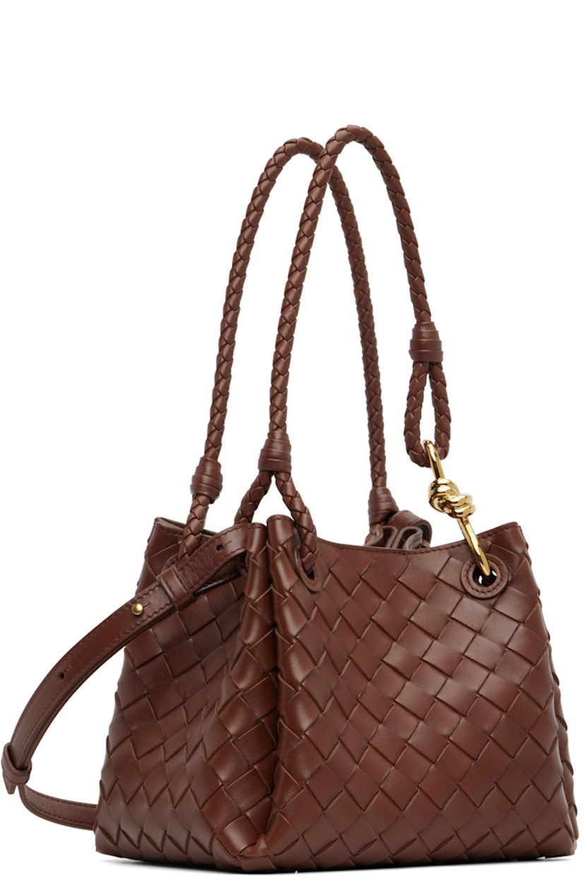 Intrecciato-woven buffed lambskin shoulder bag.

· Fixed shoulder straps with knot hardware 
· Adjustable and detachable crossbody strap
· Magnetic closure
· H7.5" x W9" x D6"

Supplier color: Sapele