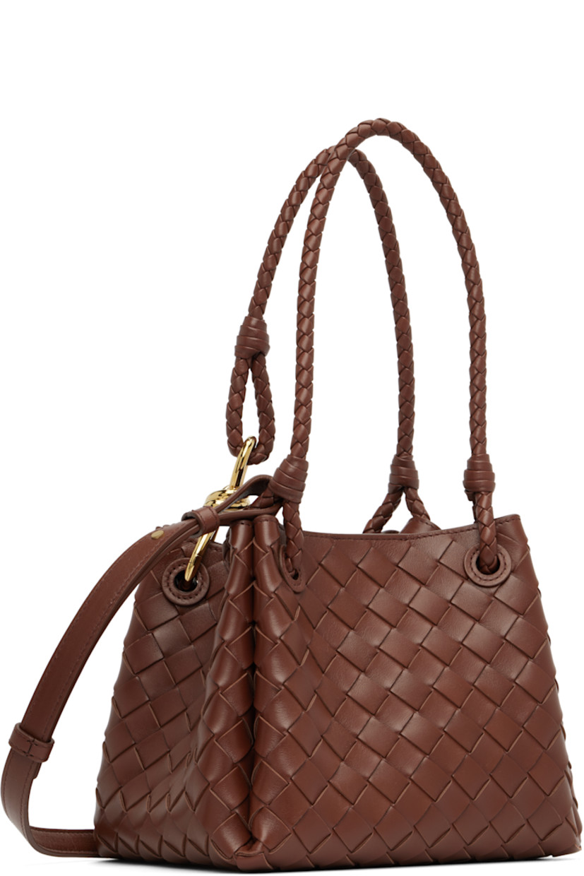 Intrecciato-woven buffed lambskin shoulder bag.

· Fixed shoulder straps with knot hardware 
· Adjustable and detachable crossbody strap
· Magnetic closure
· H7.5" x W9" x D6"

Supplier color: Sapele
