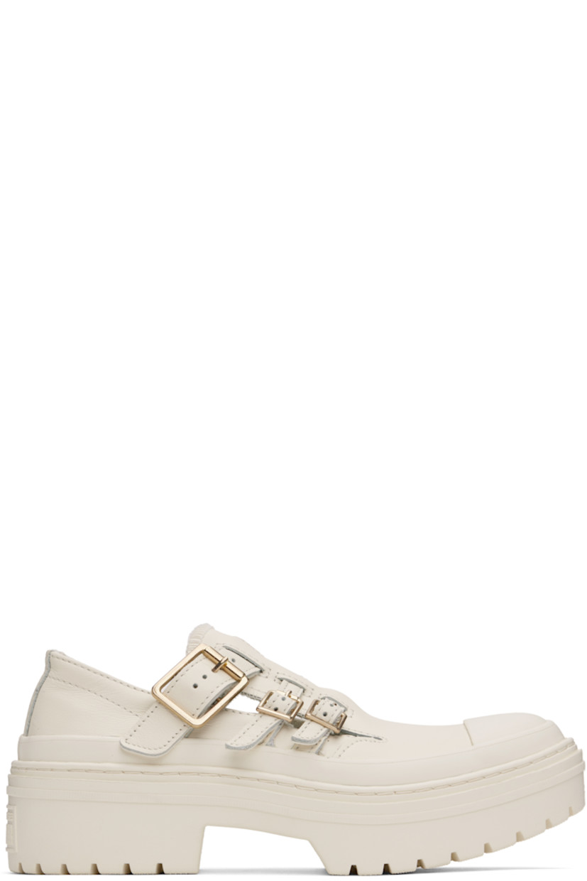 Low-top grained leather Mary Jane-style sneakers in off-white.

· Rubber cap toe
· Pin-buckle straps at vamp
· Cushioned OrthoLite® insole
· Rubberized logo patch at heel
· Treaded rubber sole 
· Platform: H2"

Supplier color: Egret/Egret/Gold