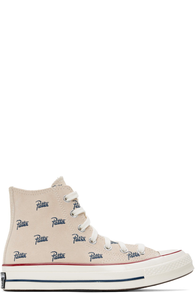 High-top suede sneakers in off-white.

· Logo pattern embroidered throughout
· Rubber cap toe
· Lace-up closure
· Logo patch and eyelets at inner side
· Canvas lining
· Rubberized logo patch at heel
· Treaded rubber sole

Part of the Converse x Patta collaboration.

Supplier color: Natural ivory/Insignia blue