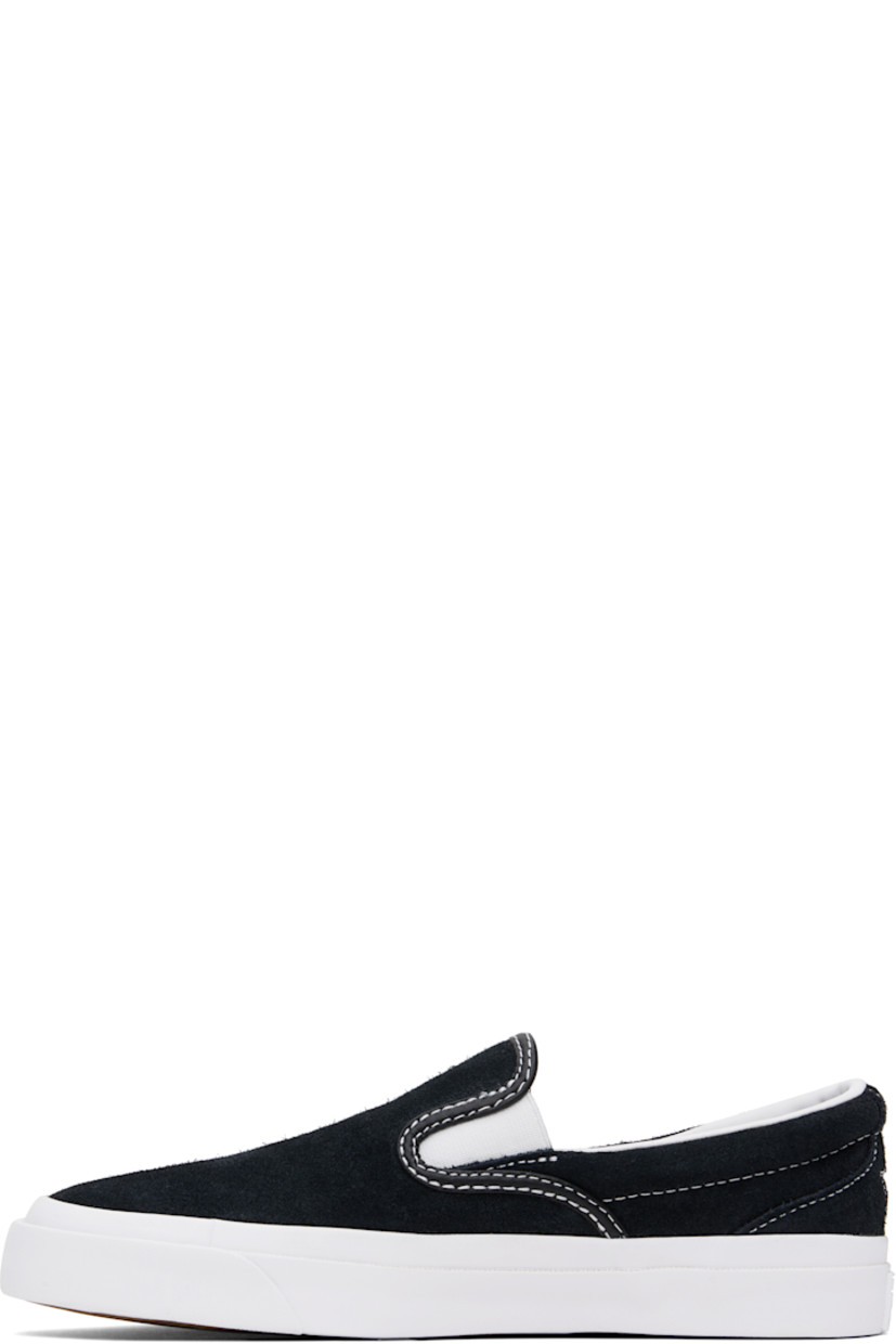 Low-top suede slip-on sneakers in black.

· Elasticized gussets at vamp
· Padded collar
· Logo cutout at heel counter
· Cushioned CX foam insole
· Suede lining
· Rubber logo patch at heel
· Textured rubber midsole
· CONS treaded rubber sole
· Contrast stitching in white

Supplier color: Black/White/White