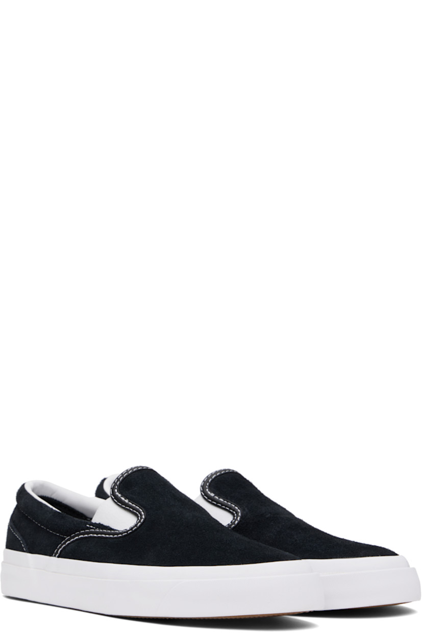 Low-top suede slip-on sneakers in black.

· Elasticized gussets at vamp
· Padded collar
· Logo cutout at heel counter
· Cushioned CX foam insole
· Suede lining
· Rubber logo patch at heel
· Textured rubber midsole
· CONS treaded rubber sole
· Contrast stitching in white

Supplier color: Black/White/White