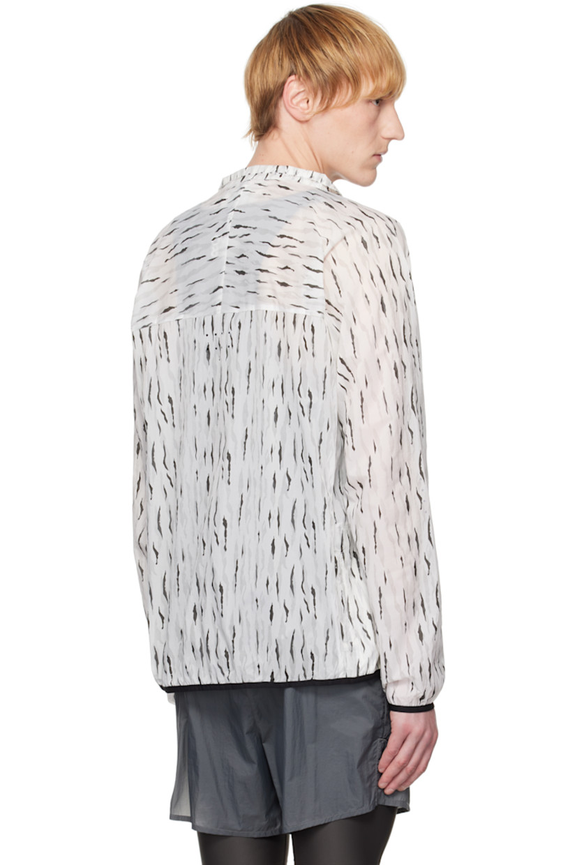 Semi-sheer nylon taffeta jacket. Graphic pattern printed throughout. 

· Stand collar 
· Zip closure 
· Logo bonded at chest
· Zip pocket at front
· Elasticized hem and cuffs
· Mesh patch pockets at side
· Unlined

Supplier color: Eric