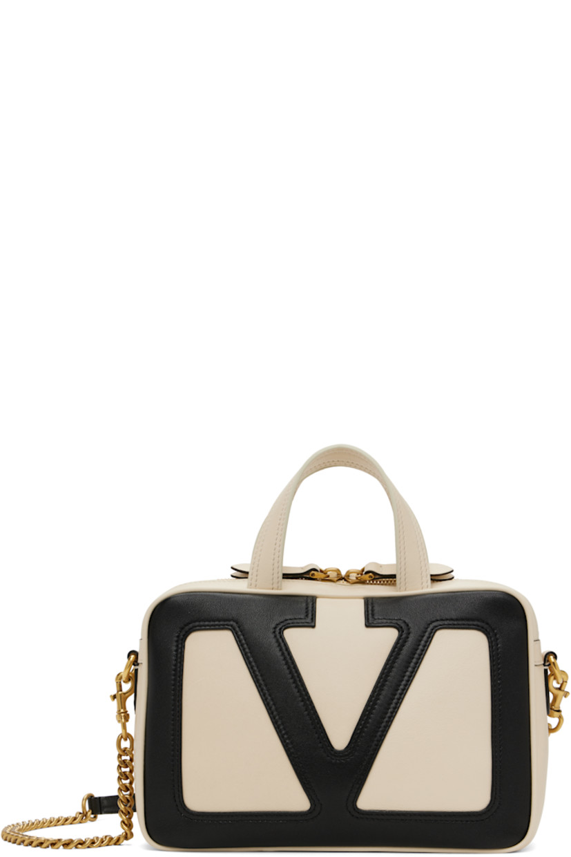 Buffed nappa leather top handle bag in off-white and black.

· Fixed carry handles
· Adjustable and detachable crossbody strap
· Detachable curb chain shoulder strap
· Logo appliqué at face
· Zip pocket at back face
· Two-way zip closure
· Zip pocket at interior
· H6" x W9" x D3"

Supplier color: Butter/Black