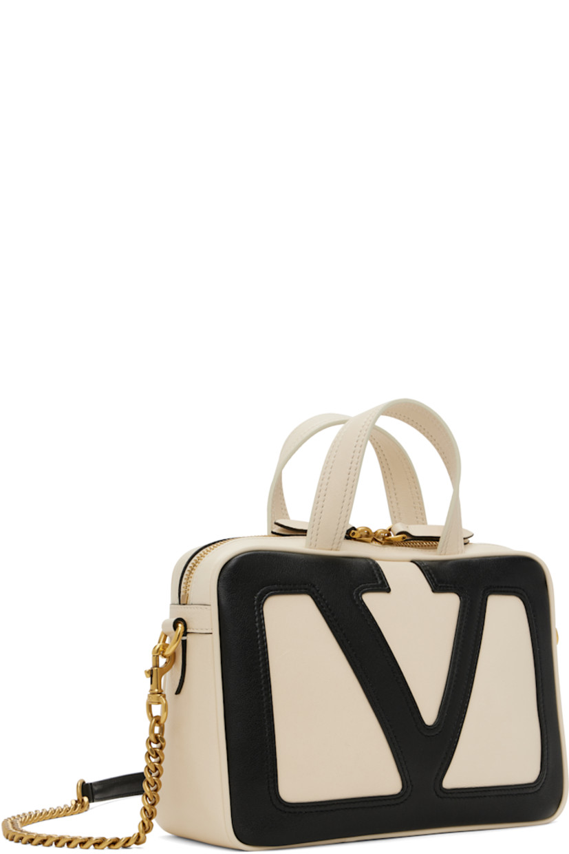 Buffed nappa leather top handle bag in off-white and black.

· Fixed carry handles
· Adjustable and detachable crossbody strap
· Detachable curb chain shoulder strap
· Logo appliqué at face
· Zip pocket at back face
· Two-way zip closure
· Zip pocket at interior
· H6" x W9" x D3"

Supplier color: Butter/Black