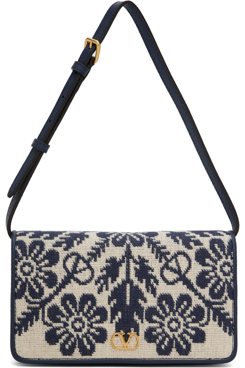 Canvas and grained leather shoulder bag in beige and navy.

· Jacquard floral pattern throughout
· Adjustable and detachable shoulder strap
· Logo hardware at face
· Magnetic flap closure
· Zip pocket at interior 
· Three card slots
· Buffed nappa leather lining 
· Gold-tone hardware
· H5" x W8" x D2"

Supplier color: Avorio blue/Dark