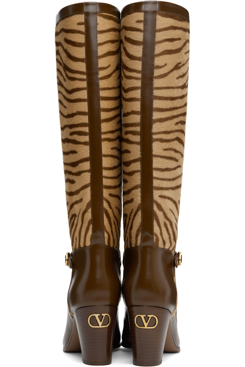Knee-high calf-hair and buffed calfskin boots in brown and beige. 

· Graphic pattern printed throughout
· Pin-buckle strap at vamp
· Buffed leather lining
· Logo hardware at heel
· Stacked leather block heel with rubber injection 
· Leather sole
· Antiqued brass-tone hardware
· Heel: H3"

Supplier color: Beige/Tobacco