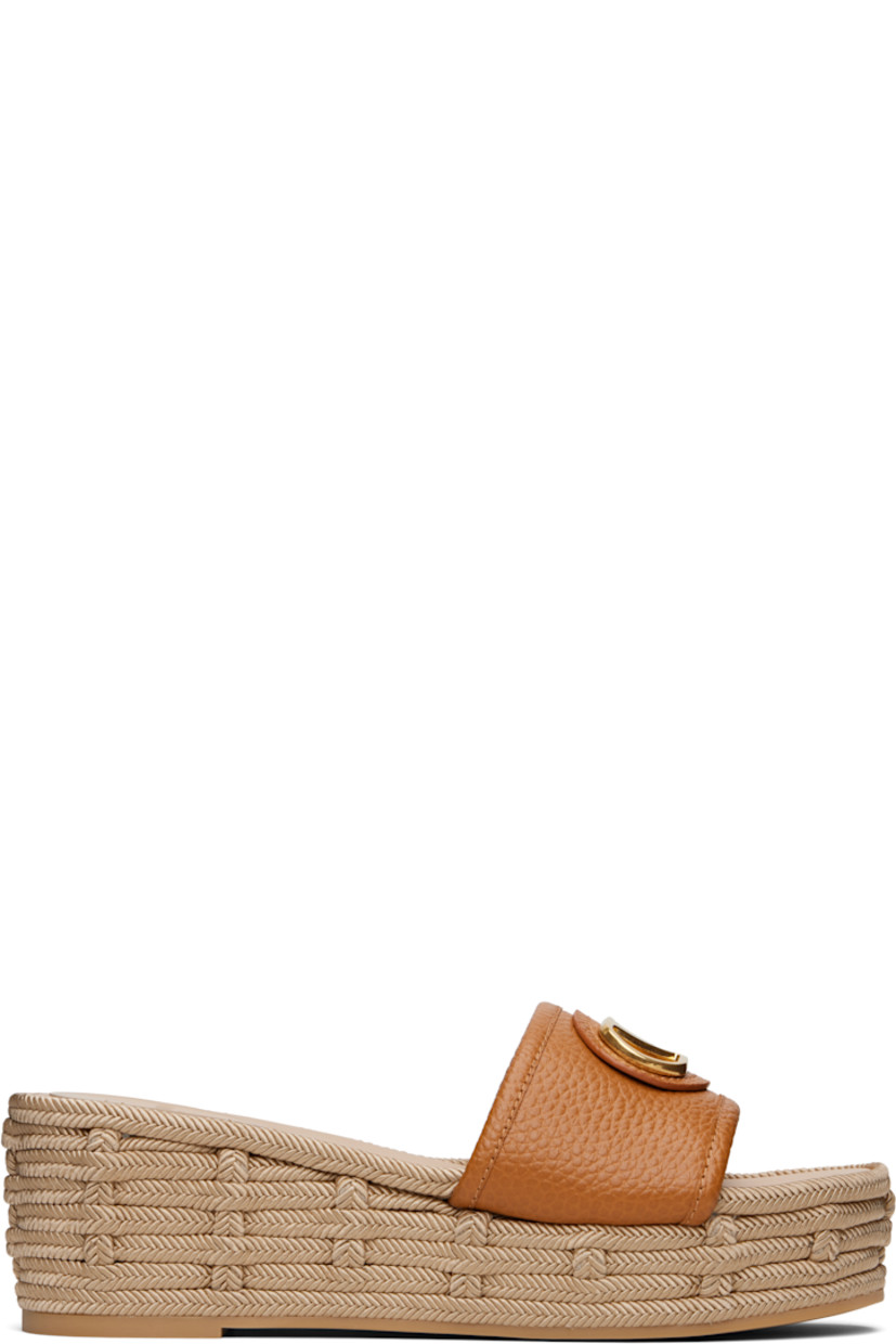 Grained leather flat sandals in brown.

· Open toe
· Logo hardware at vamp
· Logo patch at padded footbed
· Buffed leather lining
· Braided platform midsole
· Rubber sole
· Platform: H2.25"

Supplier color: Almond beige