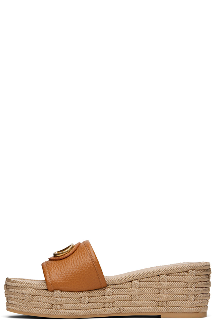 Grained leather flat sandals in brown.

· Open toe
· Logo hardware at vamp
· Logo patch at padded footbed
· Buffed leather lining
· Braided platform midsole
· Rubber sole
· Platform: H2.25"

Supplier color: Almond beige