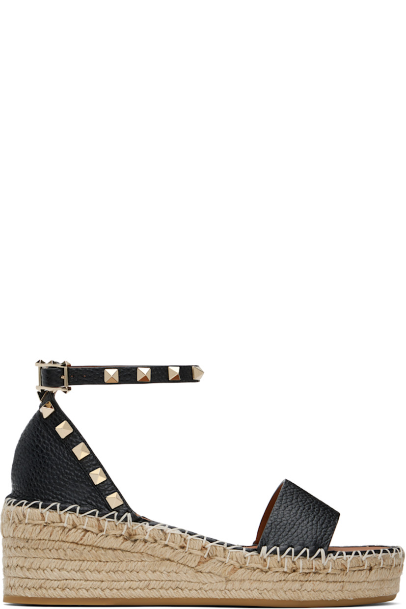 Grained calfskin flat sandals in black.

· Signature pyramid studs throughout
· Strap at vamp
· Pin-buckle ankle strap
· Logo patch at padded footbed
· Blanket stitching at welt
· Braided raffia platform midsole
· Rubber sole
· Platform: H1.25"
· Heel: H2.25"

Supplier color: Nero/Light cuir