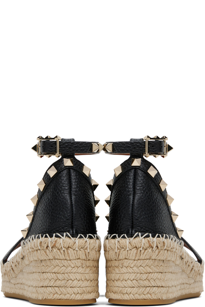 Grained calfskin flat sandals in black.

· Signature pyramid studs throughout
· Strap at vamp
· Pin-buckle ankle strap
· Logo patch at padded footbed
· Blanket stitching at welt
· Braided raffia platform midsole
· Rubber sole
· Platform: H1.25"
· Heel: H2.25"

Supplier color: Nero/Light cuir