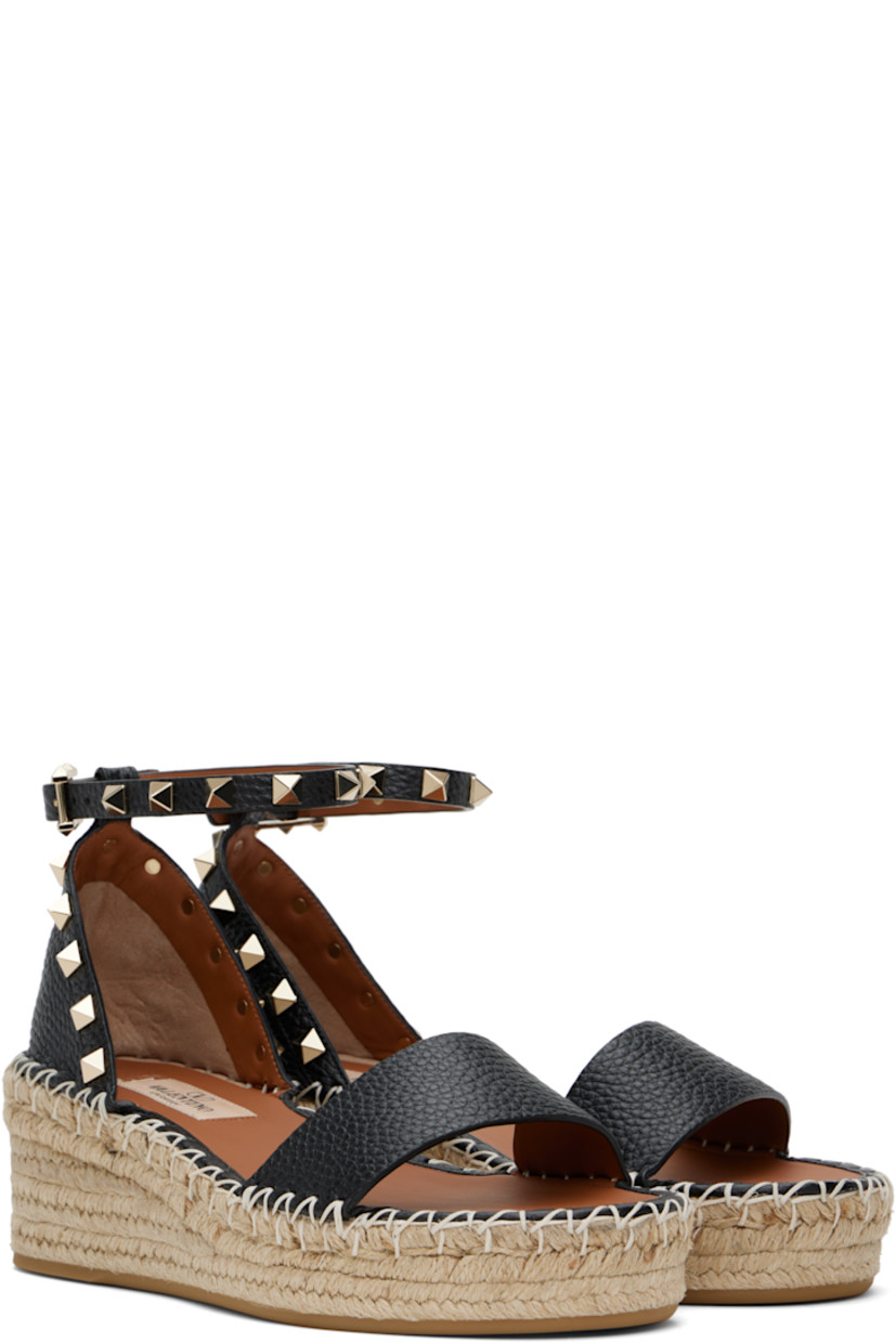 Grained calfskin flat sandals in black.

· Signature pyramid studs throughout
· Strap at vamp
· Pin-buckle ankle strap
· Logo patch at padded footbed
· Blanket stitching at welt
· Braided raffia platform midsole
· Rubber sole
· Platform: H1.25"
· Heel: H2.25"

Supplier color: Nero/Light cuir