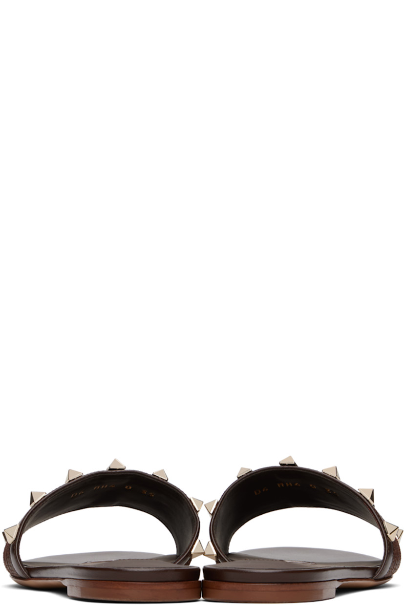 Buffed leather and woven flat sandals in brown.

· Open toe
· Signature pyramid studs at vamp
· Logo patch at padded footbed
· Buffed leather lining
· Leather heel with rubber injection
· Leather sole

Supplier color: Fondant