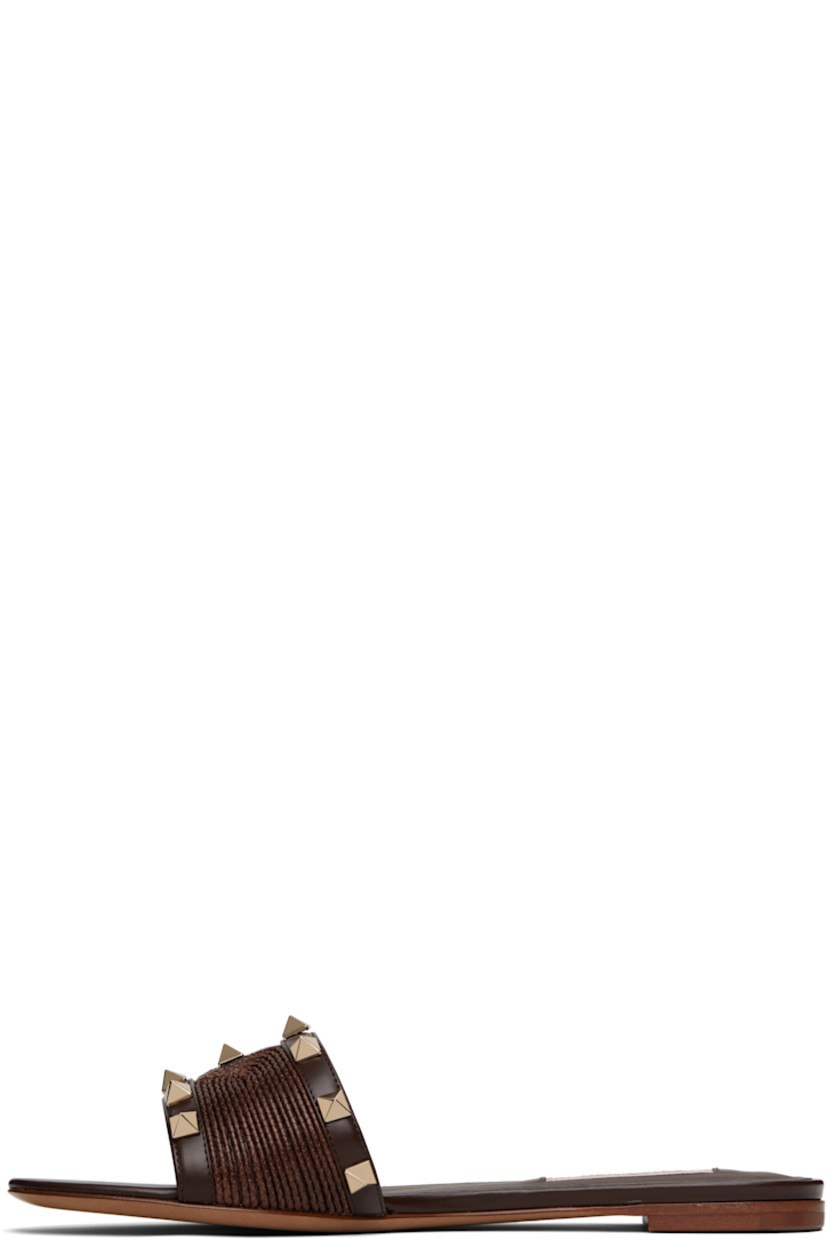 Buffed leather and woven flat sandals in brown.

· Open toe
· Signature pyramid studs at vamp
· Logo patch at padded footbed
· Buffed leather lining
· Leather heel with rubber injection
· Leather sole

Supplier color: Fondant
