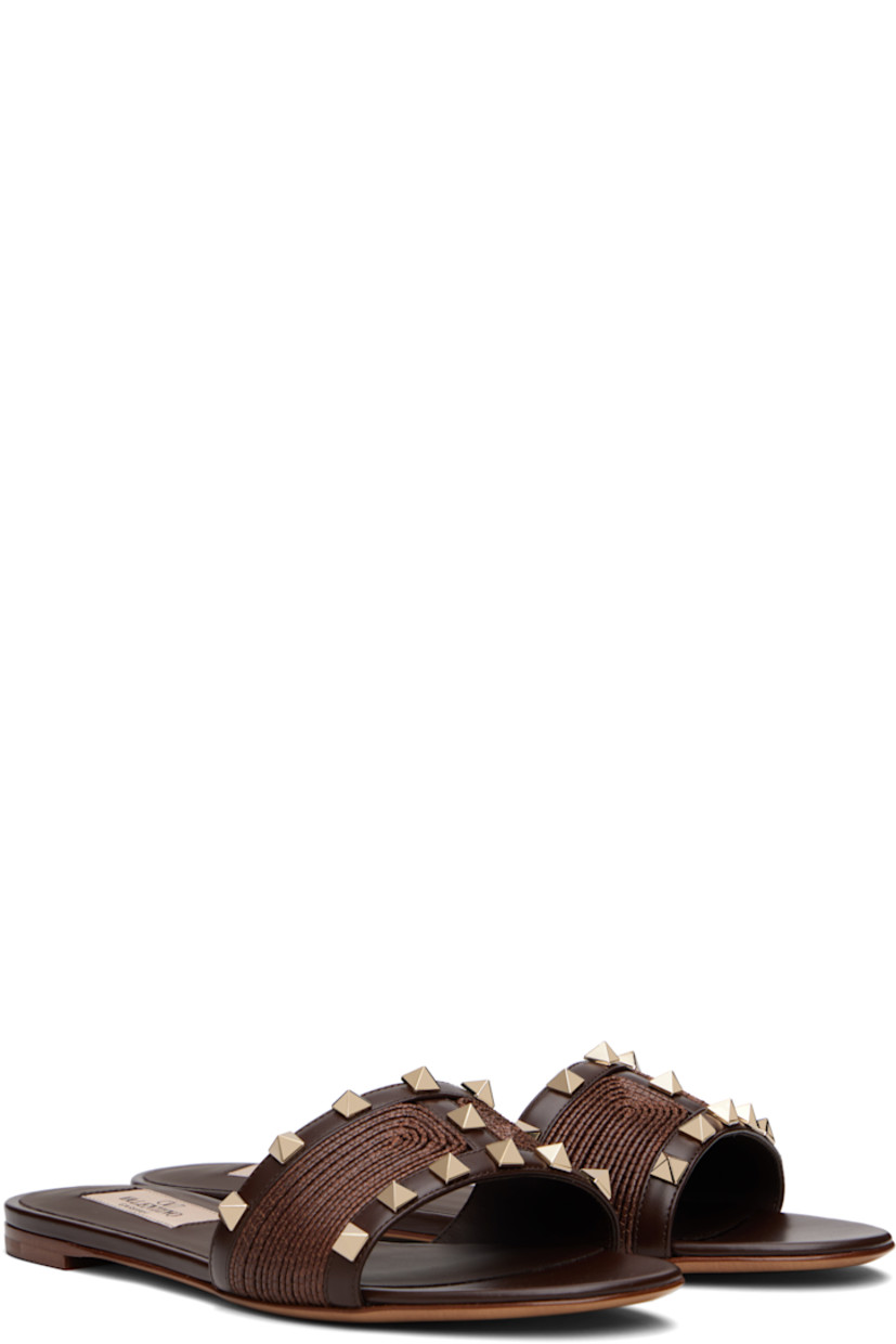 Buffed leather and woven flat sandals in brown.

· Open toe
· Signature pyramid studs at vamp
· Logo patch at padded footbed
· Buffed leather lining
· Leather heel with rubber injection
· Leather sole

Supplier color: Fondant