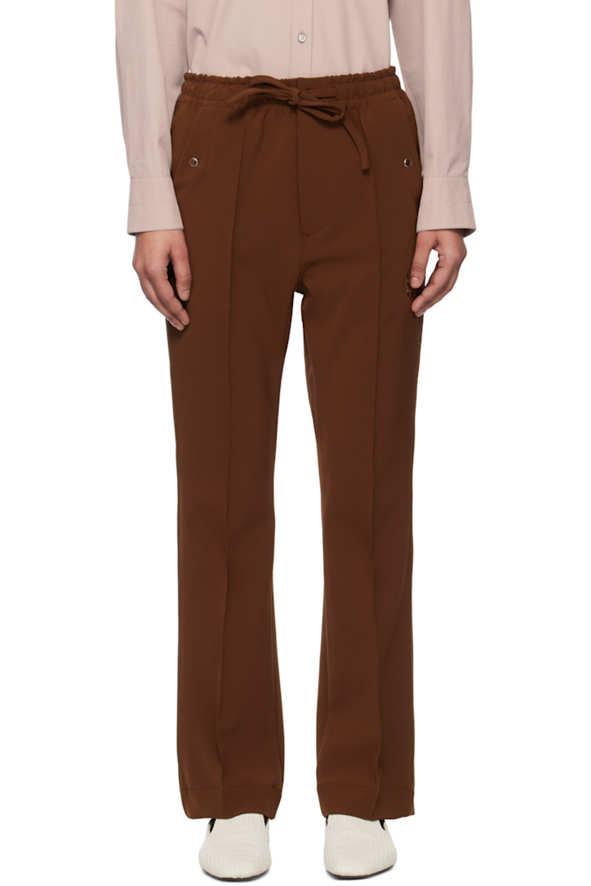 Stretch polyester double cloth trousers. 
 
· Drawstring at elasticized waistband
· Four-pocket styling
· Zip fly
· Logo embroidered at front 
· Pinched seam at front legs
· Satin piping at outseams

Supplier color: Brown