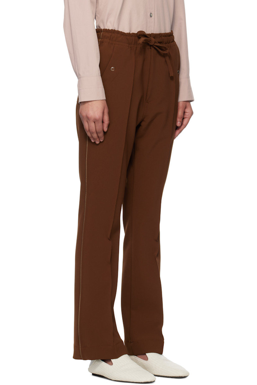 Stretch polyester double cloth trousers. 
 
· Drawstring at elasticized waistband
· Four-pocket styling
· Zip fly
· Logo embroidered at front 
· Pinched seam at front legs
· Satin piping at outseams

Supplier color: Brown