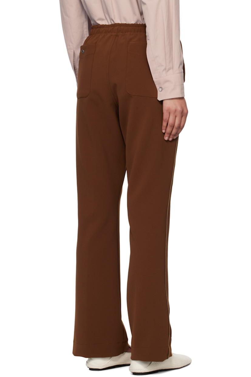 Stretch polyester double cloth trousers. 
 
· Drawstring at elasticized waistband
· Four-pocket styling
· Zip fly
· Logo embroidered at front 
· Pinched seam at front legs
· Satin piping at outseams

Supplier color: Brown