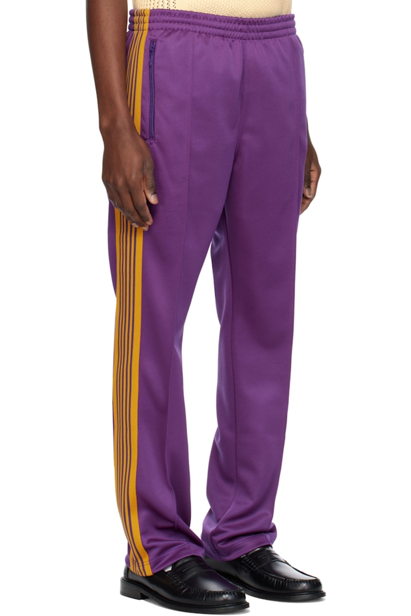 Polyester interlock jersey track pants.

· Concealed drawstring at elasticized waistband
· Three-pocket styling
· Pinched seams and embroidered logo graphic at front
· Striped knit trim at outseams

Supplier color: Purple