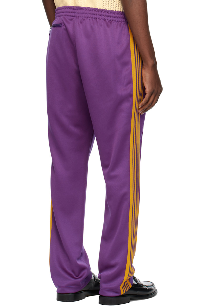 Polyester interlock jersey track pants.

· Concealed drawstring at elasticized waistband
· Three-pocket styling
· Pinched seams and embroidered logo graphic at front
· Striped knit trim at outseams

Supplier color: Purple