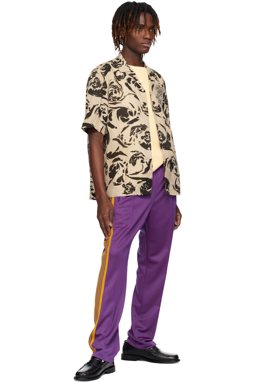 Polyester interlock jersey track pants.

· Concealed drawstring at elasticized waistband
· Three-pocket styling
· Pinched seams and embroidered logo graphic at front
· Striped knit trim at outseams

Supplier color: Purple