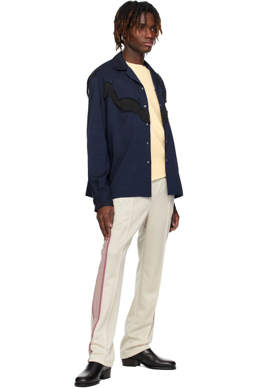 Polyester interlock jersey track pants.

· Concealed drawstring at elasticized waistband
· Three-pocket styling
· Pinched seams and embroidered logo graphic at front
· Striped knit trim at outseams

Supplier color: Ivory