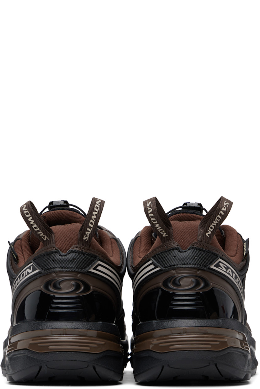 Low-top faux-leather and mesh sneakers in brown. 

· Certified OEKO-Tex® Standard and Bluesign®
· GORE-TEX™ ePE waterproof membrane, PFC-free
· Rubberized trim and bonded logos throughout
· Quicklace® closure
· Logo patch at padded tongue
· Padded collar
· SensiFit™ and sheer mesh panel at sides
· Pull-loops at heel tab
· Logo embossed at heel counter
· Molded OrthoLite® insole
· Jersey lining
· Agile Chassis™ System at rubber EnergyCell midsole
· Treaded All Terrain Contagrip® rubber sole

Supplier color: Roasted clay/Black/Rum raisin
