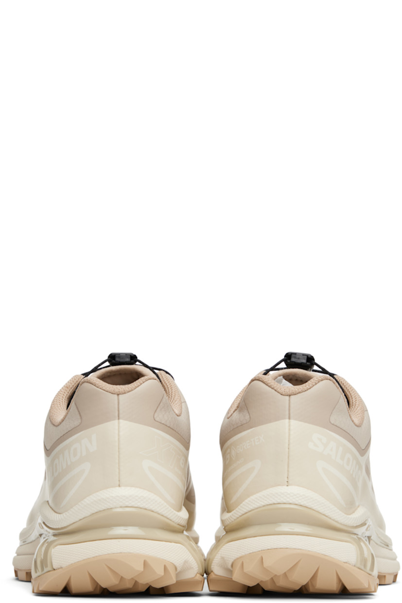 Low-top ripstop sneakers in tan and beige.

· GORE-TEX™ ePE waterproof membrane, PFC-free
· Bonded trim throughout
· Logo embossed at toe
· Quicklace™ closure
· Logo patch at vamp
· Logo-woven pull-loop at padded tongue
· Padded collar
· Bonded sensiFIT™ panel at sides
· Logo printed at outer side
· Text printed at inner side
· Molded OrthoLite® insole
· Mesh lining
· Agile Chassis™ System at EnergyCell midsole
· Treaded Mud Contagrip® rubber sole

Supplier color: Oxford tan/Almond milk/Safari