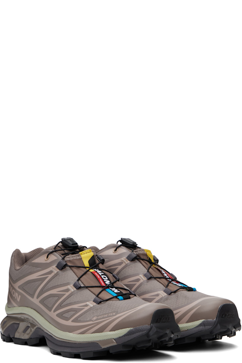 Low-top ripstop sneakers in taupe.

· GORE-TEX™ ePE waterproof membrane, PFC-free
· Bonded trim throughout
· Logo embossed at toe
· Quicklace™ closure
· Logo patch at vamp
· Logo-woven pull-loop at padded tongue
· Padded collar
· Bonded SensiFit™ panel at sides
· Logo printed at outer side
· Text printed at inner side
· Molded OrthoLite® insole
· Mesh lining
· Agile Chassis™ System at rubber EnergyCell midsole
· Treaded Mud Contagrip® rubber sole

Supplier color: Iron/Etherea/Seagrass