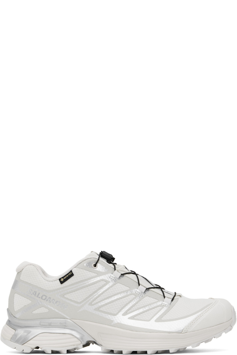 Low-top mesh sneakers in gray.

· Waterproof GORE-TEX™ membrane
· Reflective trim throughout
· Rubber cap toe
· Quicklace™ closure
· Logo patch at vamp
· Logo-woven pull-loop at padded tongue
· Padded collar
· Logo printed at sides
· Bonded SensiFit™ panel at sides
· Logo flag at outer side
· Molded OrthoLite® insole
· Mesh lining
· Agile Chassis™ System at foam rubber EnergyCell midsole
· Treaded Mud Contagrip® rubber sole

Supplier color: Lunar rock/Alloy/Ftw silver