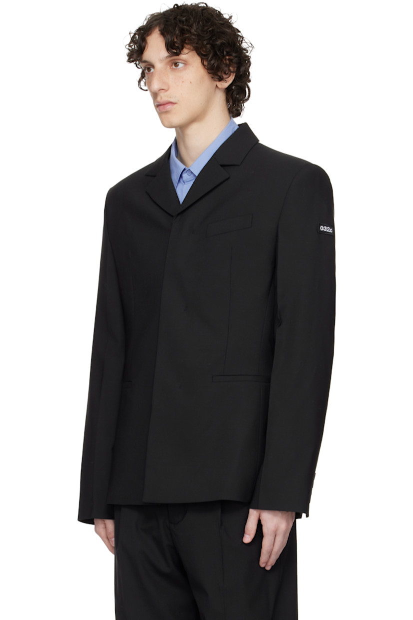Plain-woven stretch polyester- and wool-blend blazer.

· Notched lapel
· Concealed button closure
· Welt pockets and darts at front 
· Padded shoulders
· Embroidered logo patch at sleeve
· Buttoned surgeon's cuffs
· Central vent at back hem 
· Welt pockets at interior 
· Full satin lining 

Supplier color: Black